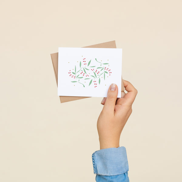 Single folded A2 greeting card with an envelope with an illustration of multiple green leaves and red berries.