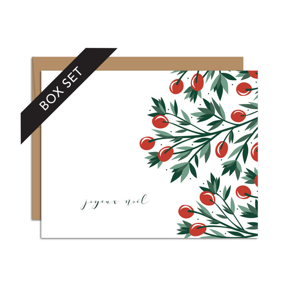 Box set of 8 folded A2 greeting cards with envelopes with an illustration  of red holly berries and green leaves bordering the right side of the card. On the bottom left side of the card is text in cursive that states "Joyeux Noel".