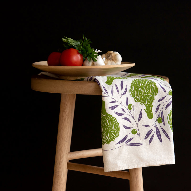 A single 100% cotton flour sack towel with an illustration of artichokes and olive vines