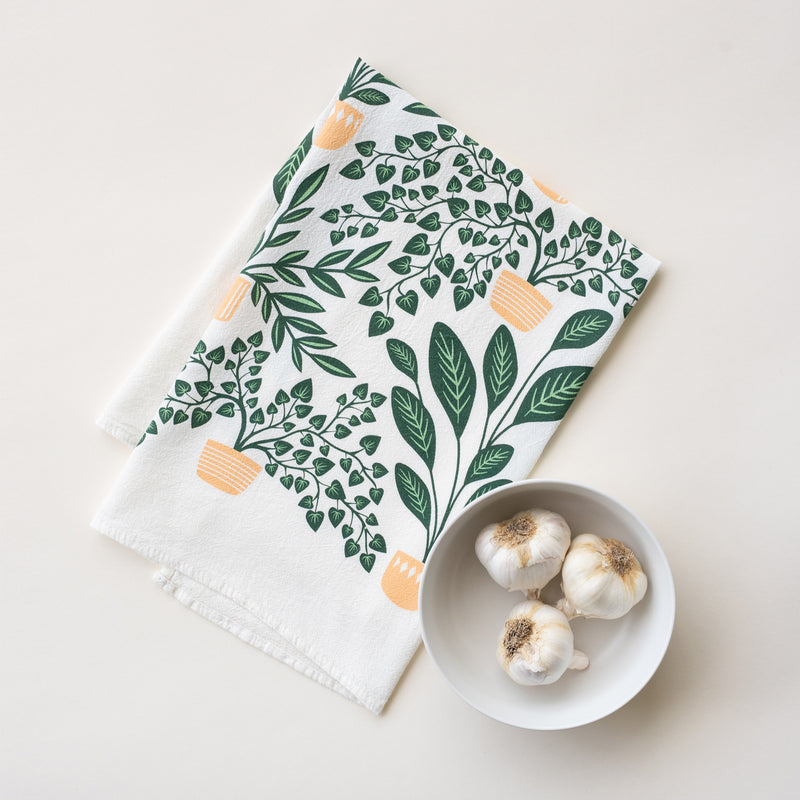 A single 100% cotton flour sack towel with an illustration of potted houseplants