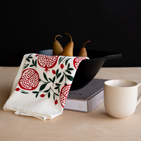 A single 100% cotton flour sack towel with an illustration of pomegranates