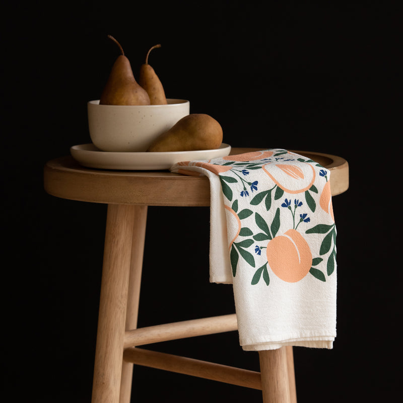 A single 100% cotton flour sack towel with an illustration of peaches