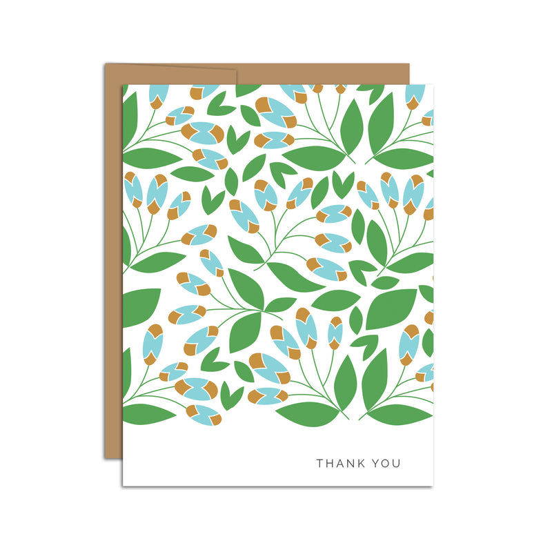Single folded A2 greeting card with an envelope with an illustration of green leaves and blue and brown detail branching off of the leaves. In the bottom right is text that states "Thank You".