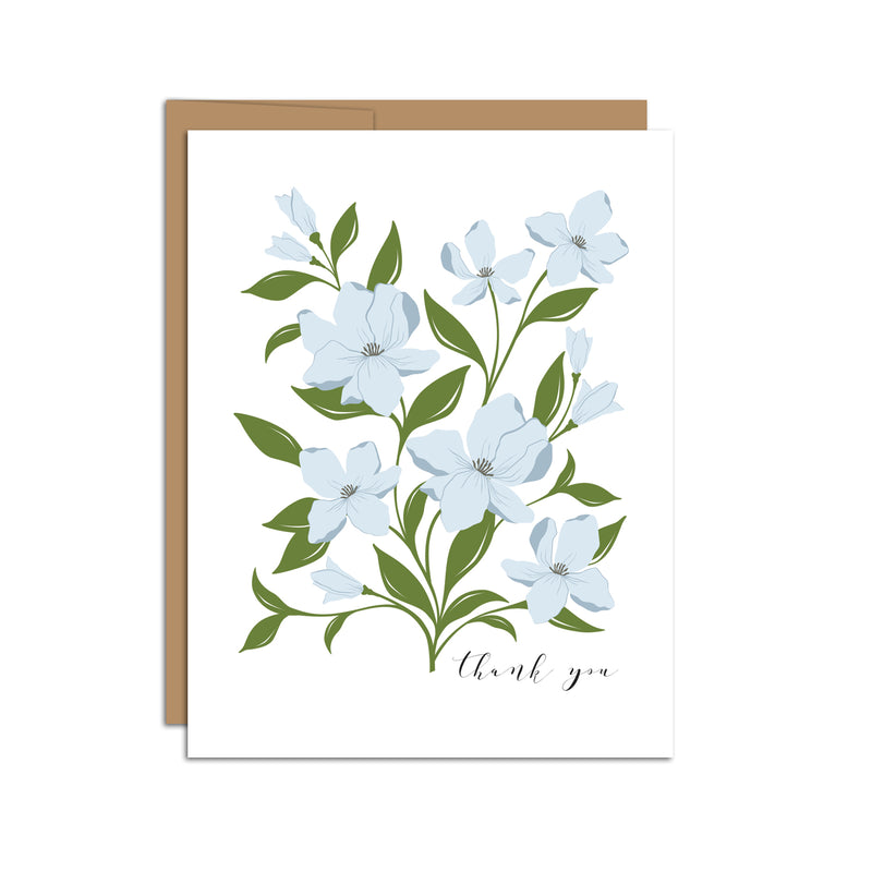 Single folded A2 greeting card with an envelope with an illustration of blue dogwood flowers and green leaves. Text below and to the right of the bouquet states "Thank You" in cursive.