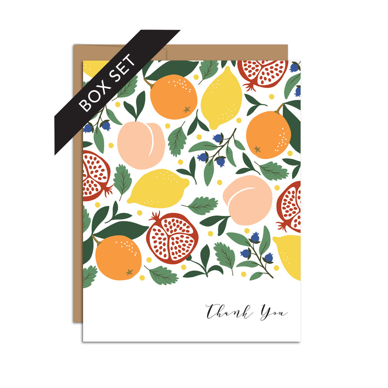 Box set of 8 folded A2 greeting cards with envelopes with an illustration  of pomegranates, lemons, oranges, blueberries, and peaches in a mixed pattern. In the bottom right is text in cursive that states "Thank You".