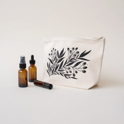 A single 10” by 7” by 3” natural cotton canvas gusseted zip pouch with an illustration of a branch and florals.